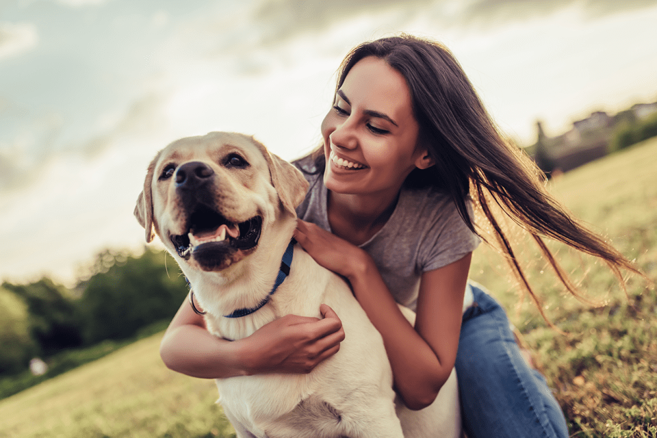 Happy pet parent and pet, close up with an open field background